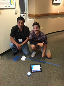 FAME students taking measurements of tape on floor using iPad